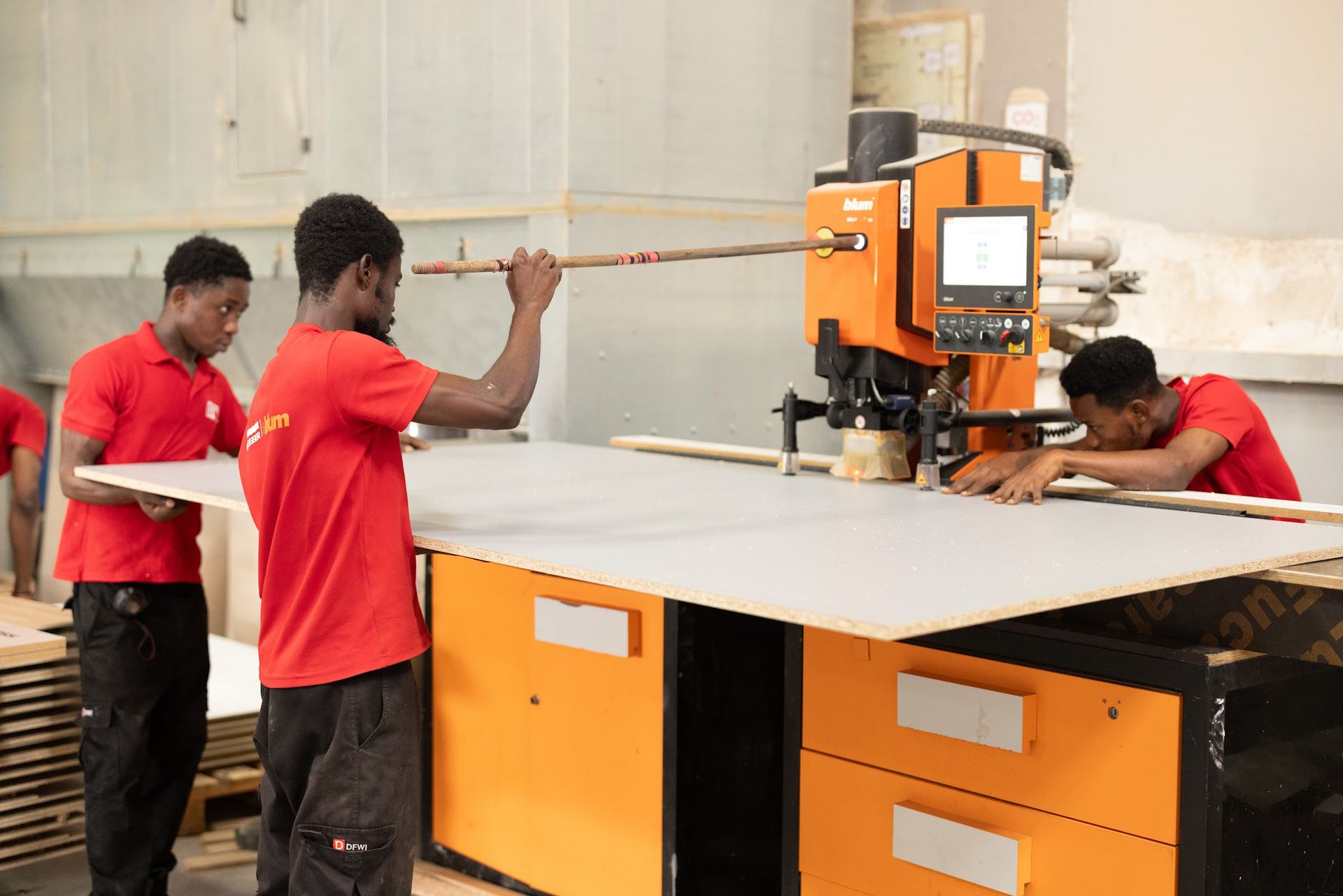 DFWI Ghana team feeding a panel through a Blum boring machine