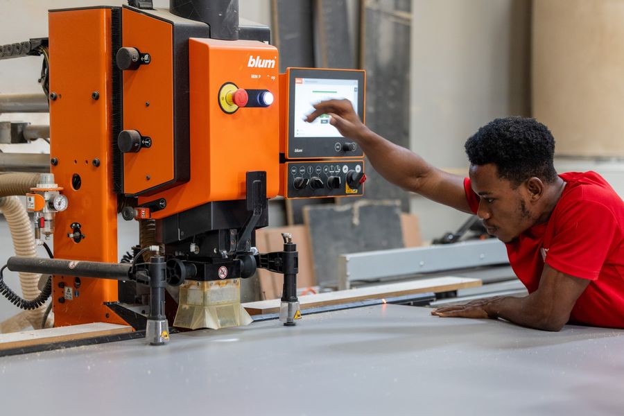 Technician adjusting a Blum boring machine