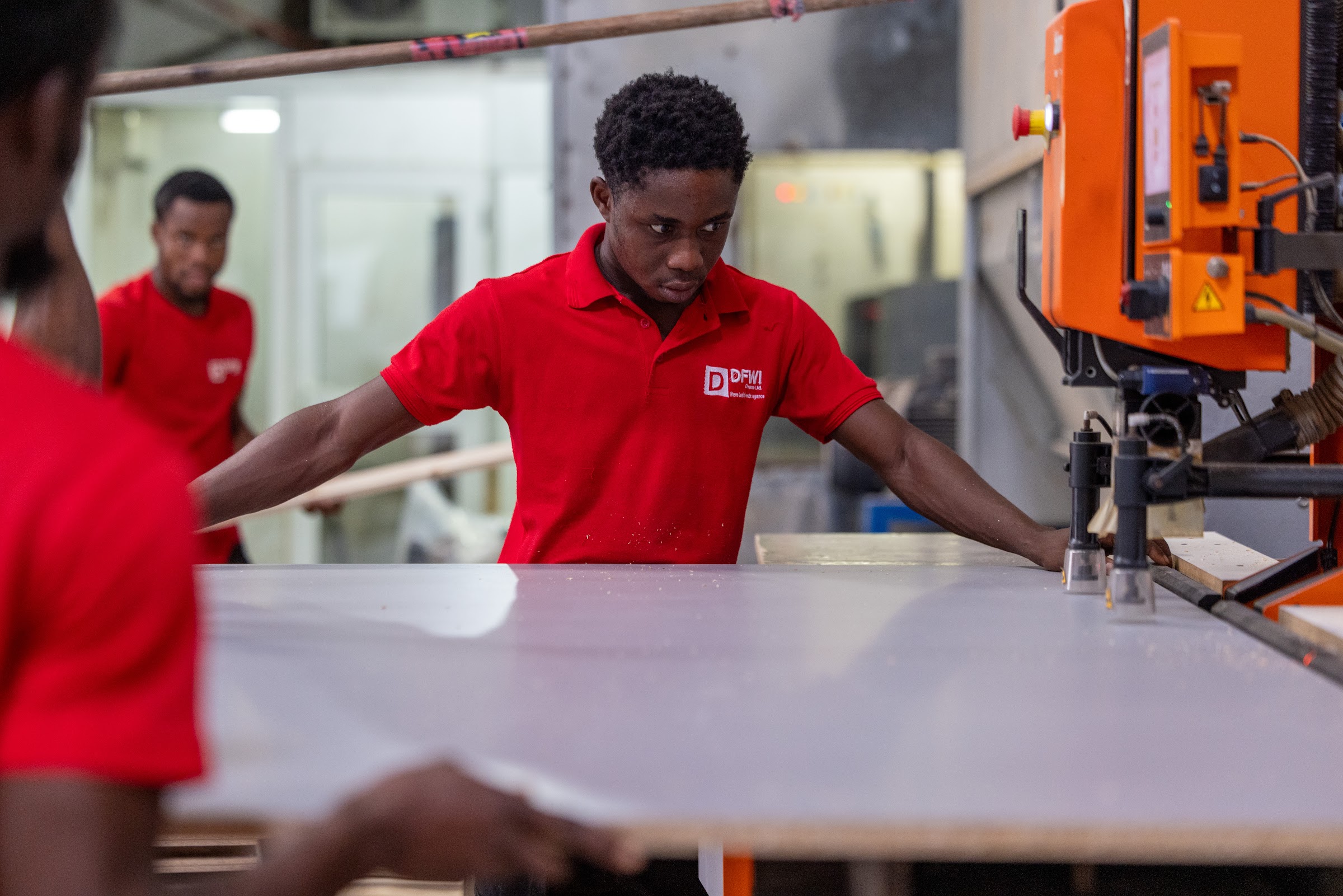 DFWI technician smiling as the team feeds a panel into a Blum boring machine